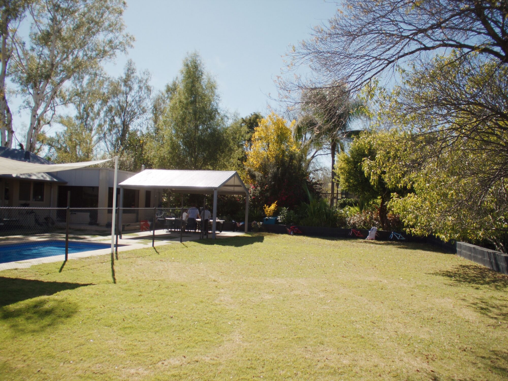 Spacious Brinkin family home backyard with a fenced pool and wide green lawn